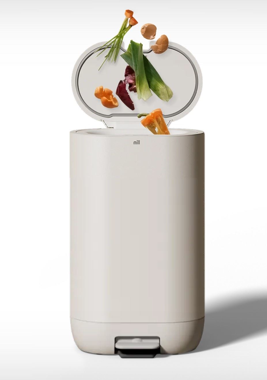 Close up of the Mill food recycler with food scraps being inserted through the top